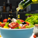 pouring olive oil on salad